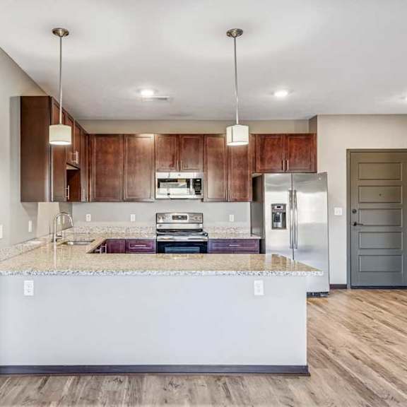 Thumbnail 50 of 51 A kitchen with a marble countertop and wooden cabinets.