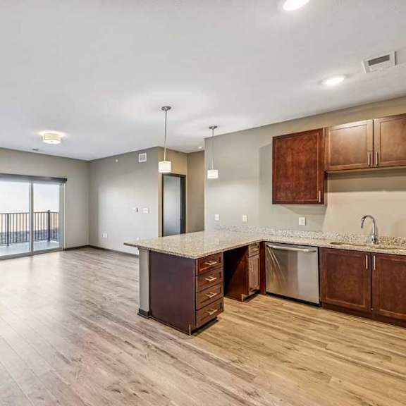 Thumbnail 37 of 51 A spacious kitchen and living room with wooden floors and modern appliances.