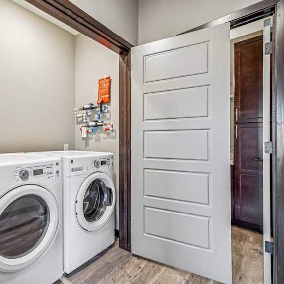 Thumbnail 39 of 51 Two white front loading washing machines in a laundry room.