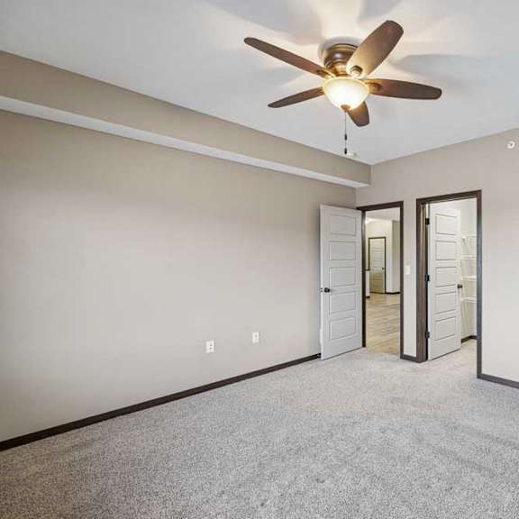 Thumbnail 28 of 33 A room with a ceiling fan and carpeted floor.