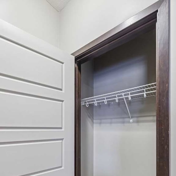 Thumbnail 32 of 33 A white closet with a glass door and a shelf.