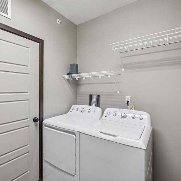 Thumbnail 22 of 33 A white washer and dryer in a small laundry room.
