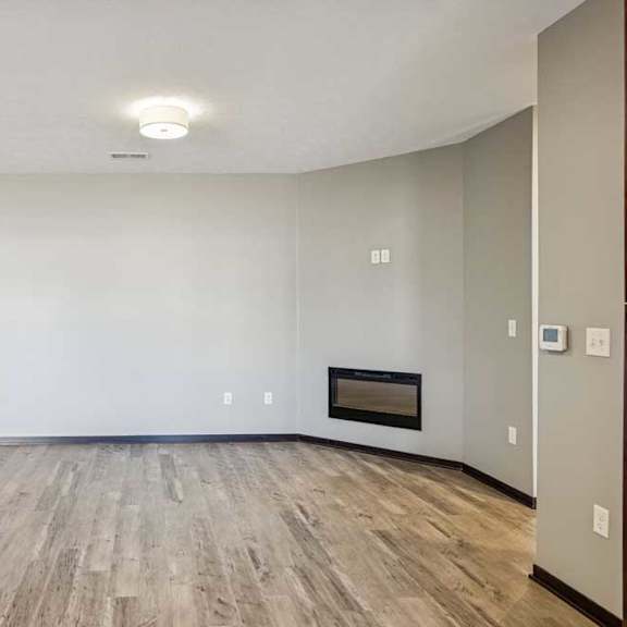 Thumbnail 2 of 16 A room with a fireplace and wood flooring.