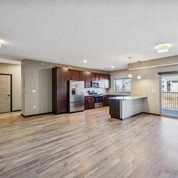 Thumbnail 8 of 16 A spacious kitchen with wooden floors and modern appliances.