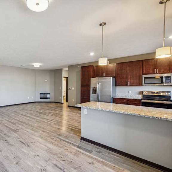Thumbnail 7 of 16 A kitchen with wooden floors and a countertop.