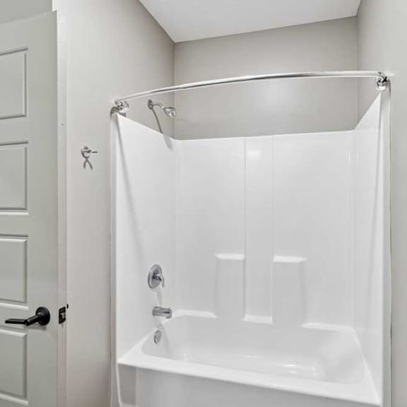 Thumbnail 17 of 22 A white bathroom with a white tub and shower curtain.
