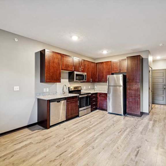 Thumbnail 19 of 22 A kitchen with wooden cabinets and a refrigerator.