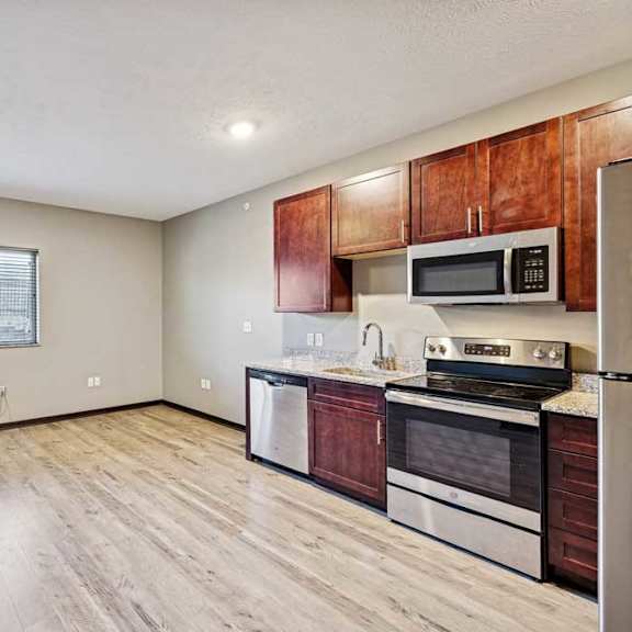 Thumbnail 11 of 22 A kitchen with wooden cabinets and stainless steel appliances.