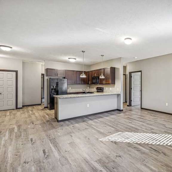 Thumbnail 26 of 45 A spacious kitchen with a white island and wooden flooring.