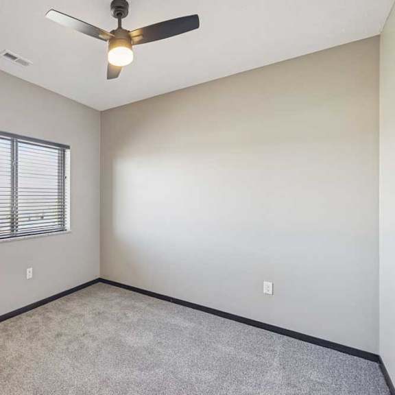 Thumbnail 41 of 43 A room with a ceiling fan and a window with blinds.