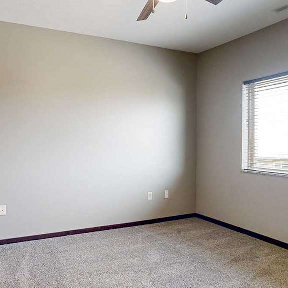 Thumbnail 20 of 51 A carpeted primary bedroom with a window and a ceiling fan.