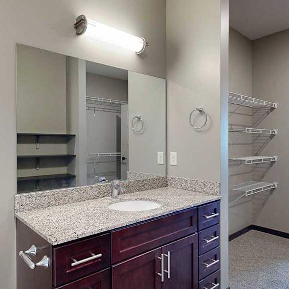 Thumbnail 23 of 51 A vanity sink with a granite countertop and mounted mirror.