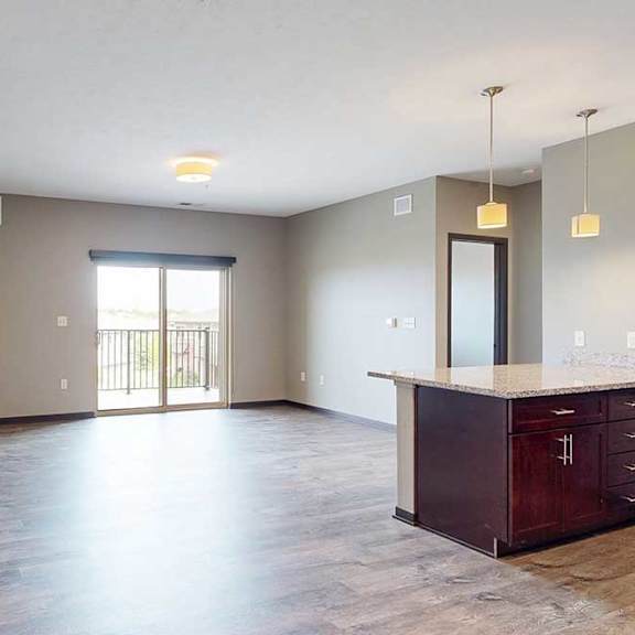 Thumbnail 2 of 51 A spacious living area with neutral walls and wood-style flooring.