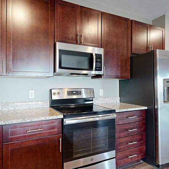 Thumbnail 8 of 51 A stainless steel stove, microwave, and fridge in a contemporary kitchen.