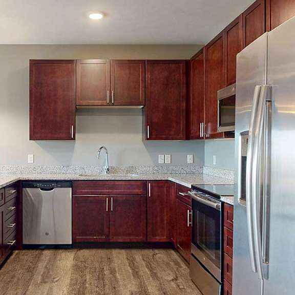Thumbnail 9 of 51 A modern kitchen with dark cabinetry, stainless steel appliances, and granite counters.