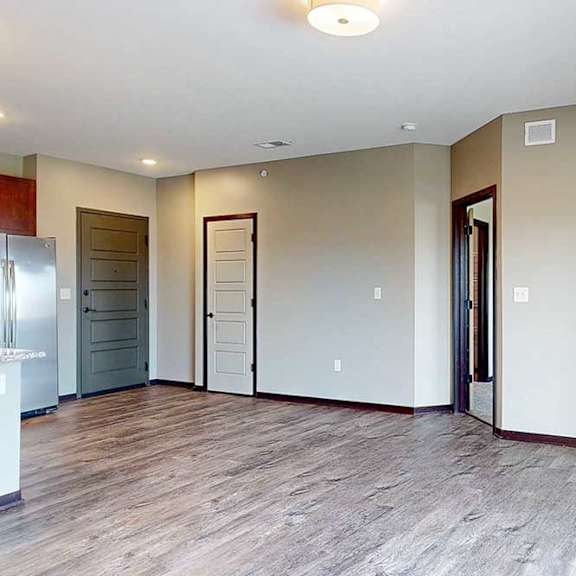 Thumbnail 17 of 51 A spacious living area with neutral walls and wood-style flooring.