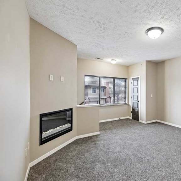 Thumbnail 20 of 25 A living room with a fireplace and carpeted floor.
