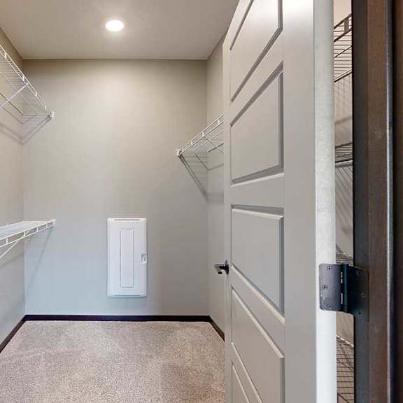 Thumbnail 25 of 33 A long walk-in closet with built-in shelving and hanging space on either side.