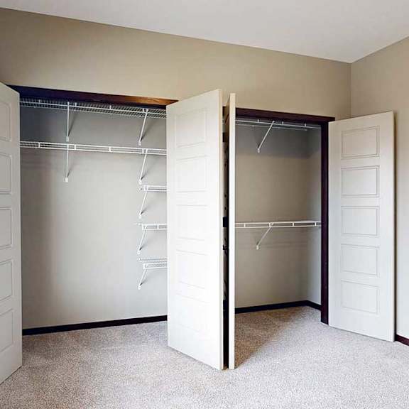 Thumbnail 30 of 33 A bedroom with a large window and two side-by-side closets with sliding double doors.