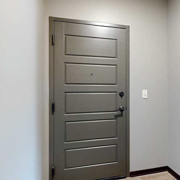 Thumbnail 2 of 33 A grey front door with a coat closet off to the right.