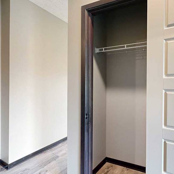 Thumbnail 4 of 33 A hallway coat closet with a built-in wire shelf for hanging space.