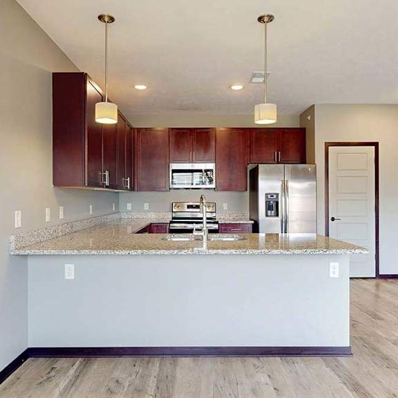 Thumbnail 10 of 33 A modern kitchen with wooden cabinets, granite counters, and stainless steel appliances.
