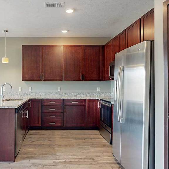 Thumbnail 14 of 33 A modern kitchen with wooden cabinets, granite counters, and stainless steel appliances.