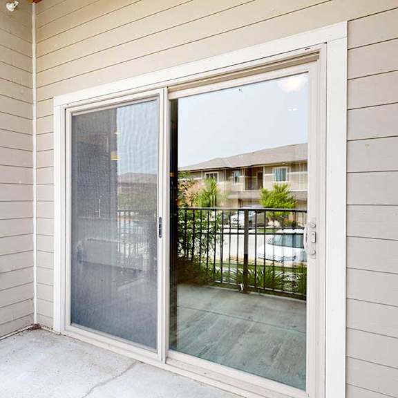 Thumbnail 19 of 33 A balcony with a metal railing, and a sliding glass door to the living room.