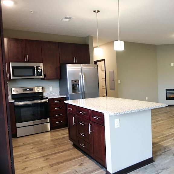 Thumbnail 4 of 43 Living and kitchen area with large island in a three bedroom Harrison floor plan
