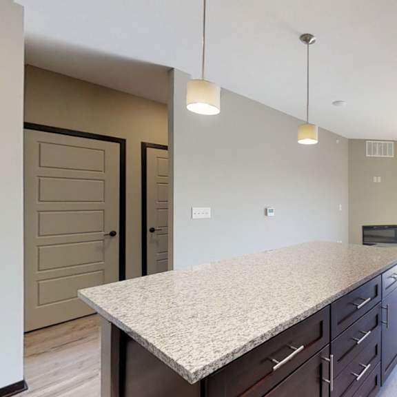 Thumbnail 4 of 10 A kitchen with a granite countertop and stainless steel appliances.
