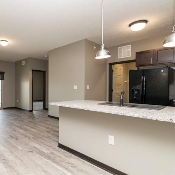 Thumbnail 2 of 14 A kitchen with a black fridge and a white countertop.