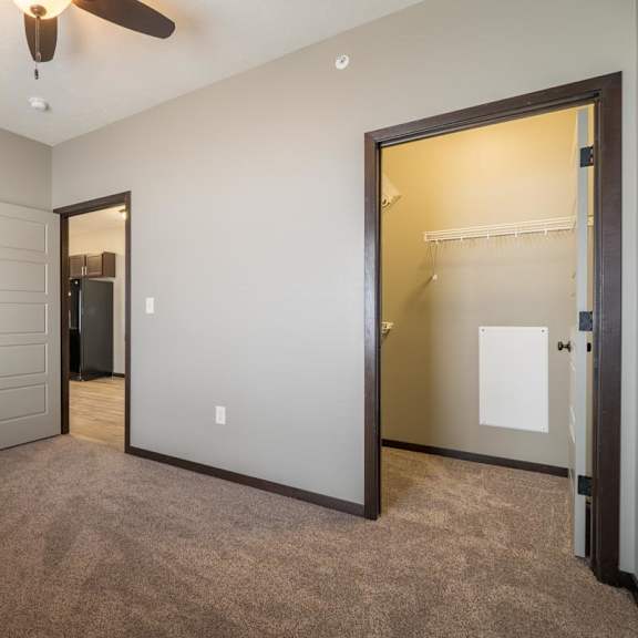 Thumbnail 7 of 9 A room with a ceiling fan and two doors.