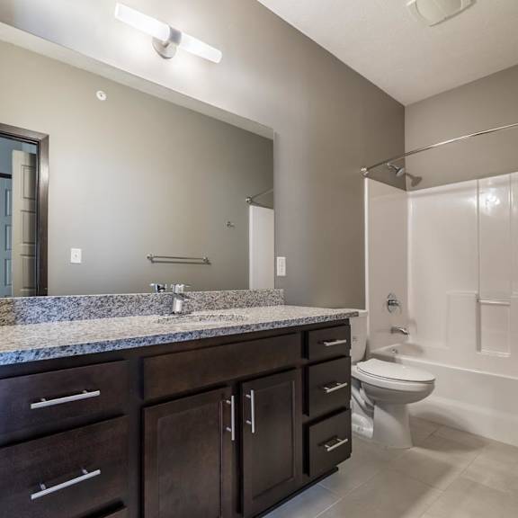 Thumbnail 9 of 9 A bathroom with a sink, toilet, and a mirror.