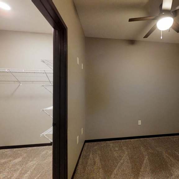 Thumbnail 7 of 10 a bedroom with carpeted flooring, a walk-in closet, and a ceiling fan