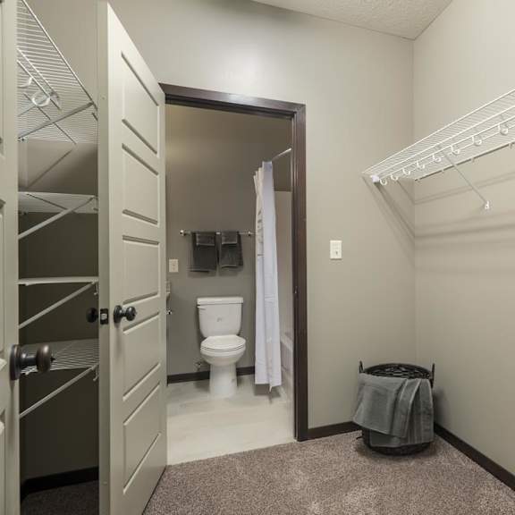 Thumbnail 9 of 12 A bathroom with a toilet, a shower, and a towel on the floor.