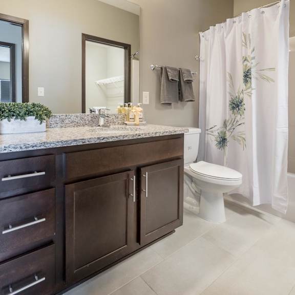 Thumbnail 10 of 12 A bathroom with a white shower curtain and a white toilet.