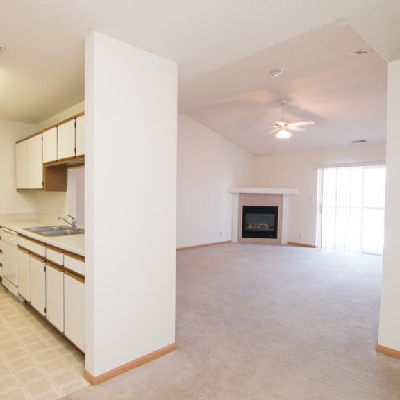 Thumbnail 2 of 15 an empty kitchen and living room with a fireplace