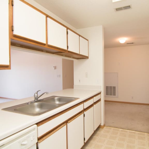 Thumbnail 5 of 15 a kitchen with white cabinets and a sink and a refrigerator