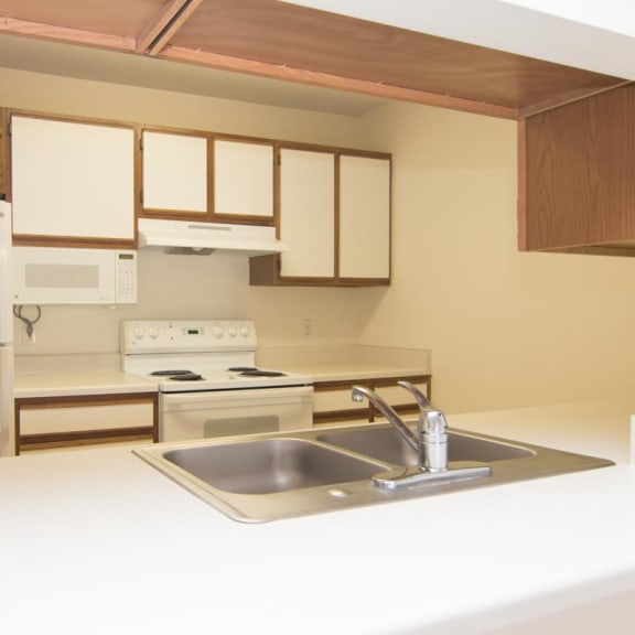 Thumbnail 7 of 15 a kitchen with a sink and a refrigerator