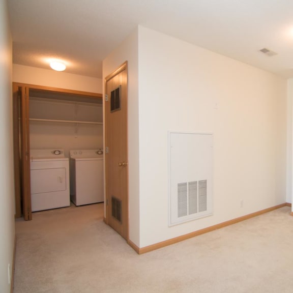 Thumbnail 10 of 15 an empty living room with a door to a laundry room