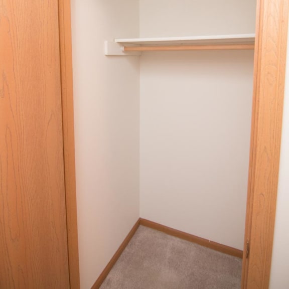 Thumbnail 12 of 15 a walk in closet with a white wall and a shelf