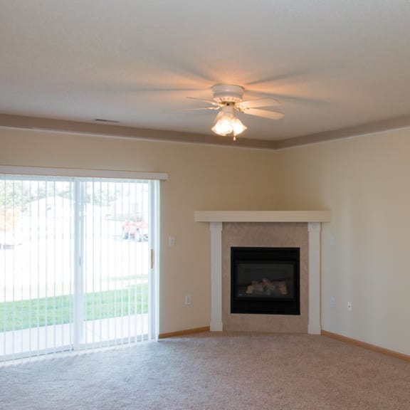 Thumbnail 5 of 13 a living room with a fireplace and a ceiling fan