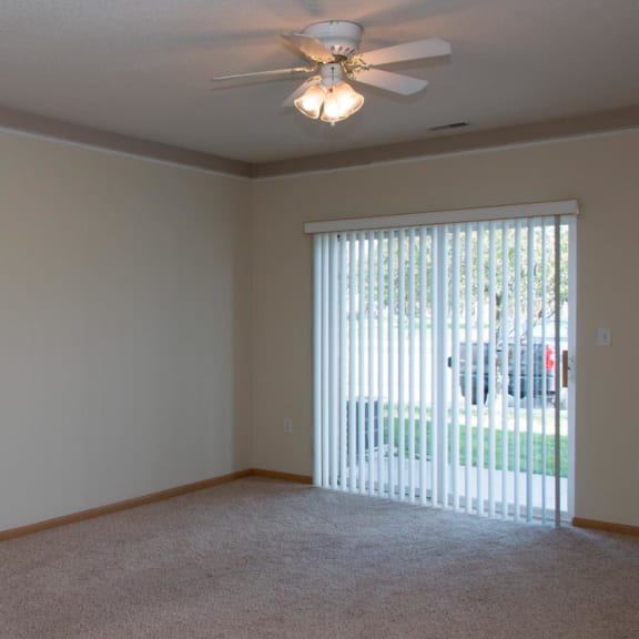 Thumbnail 6 of 13 a living room with a large window and a ceiling fan