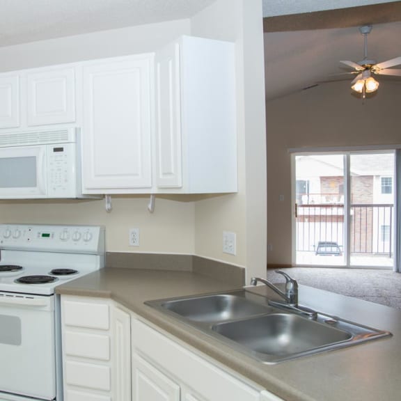 Thumbnail 4 of 21 an empty kitchen with white appliances and a sink
