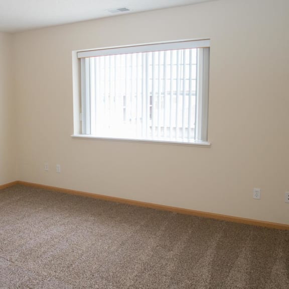 Thumbnail 10 of 21 a large room with carpet and a window