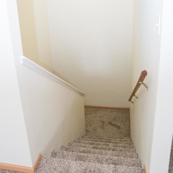 Thumbnail 18 of 21 a small hallway with a landing with a chair and a white wall and a staircase