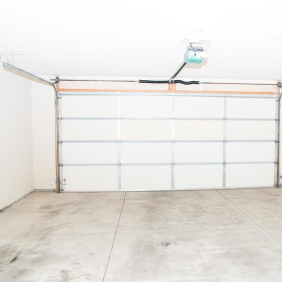 Thumbnail 21 of 21 an empty garage with a white wall and a garage door