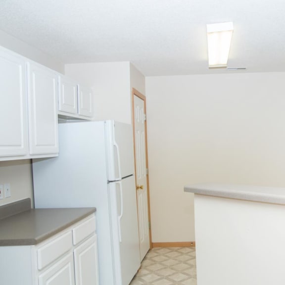 Thumbnail 3 of 21 a kitchen with white cabinets and a stove and a refrigerator