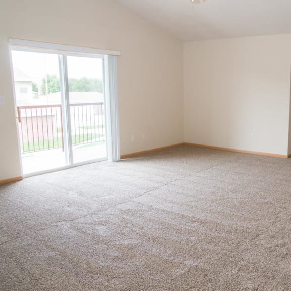 Thumbnail 9 of 21 an empty living room with a door to a balcony