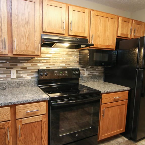 Thumbnail 4 of 27 a kitchen with black appliances and granite counter tops